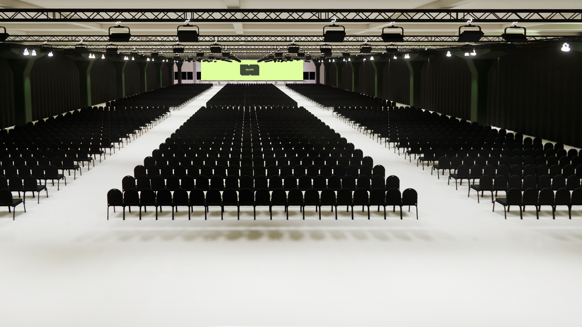 Large empty conference hall with rows of black chairs.