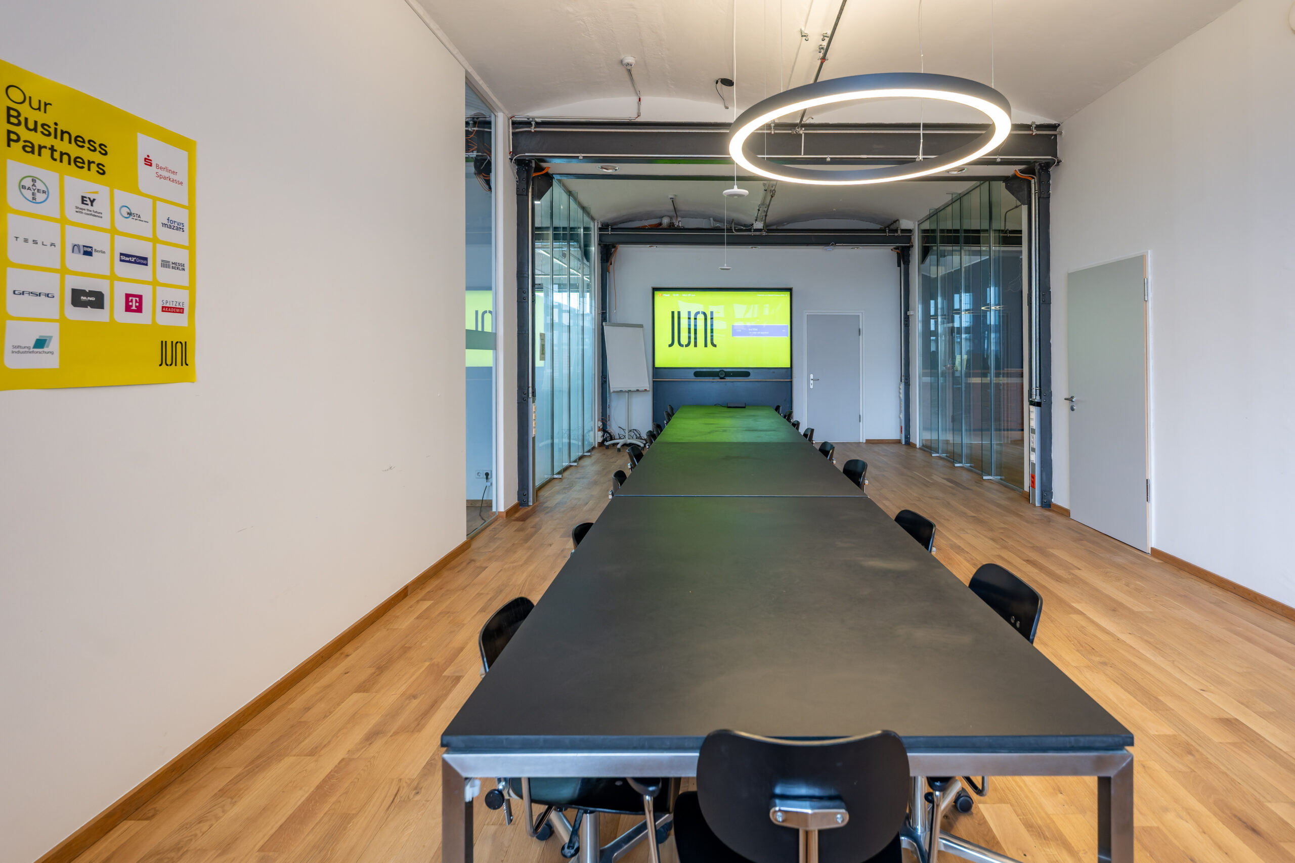 Modern conference room with long black table and ring light.