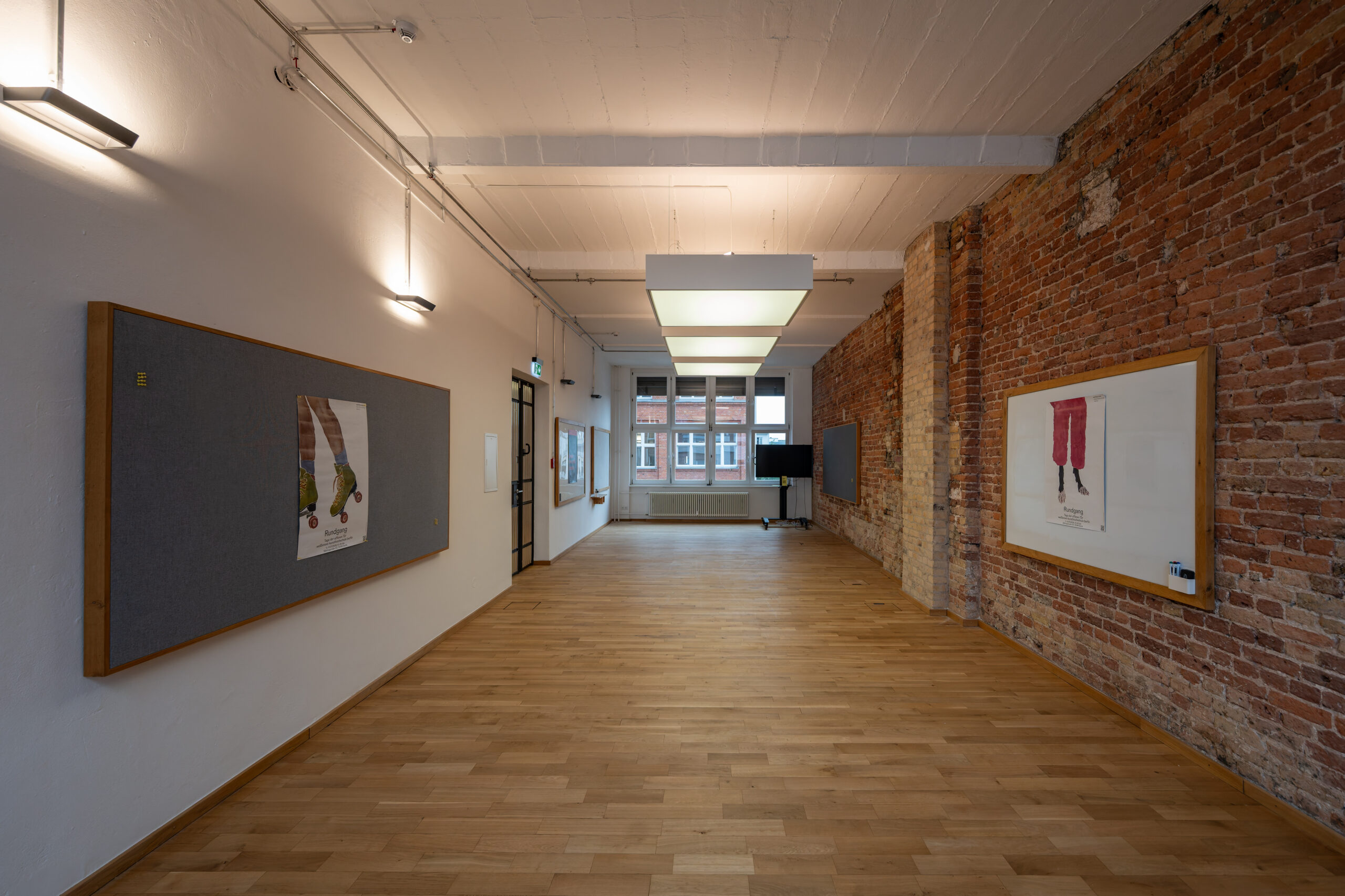 Spacious studio with exposed brick walls and wooden floors.