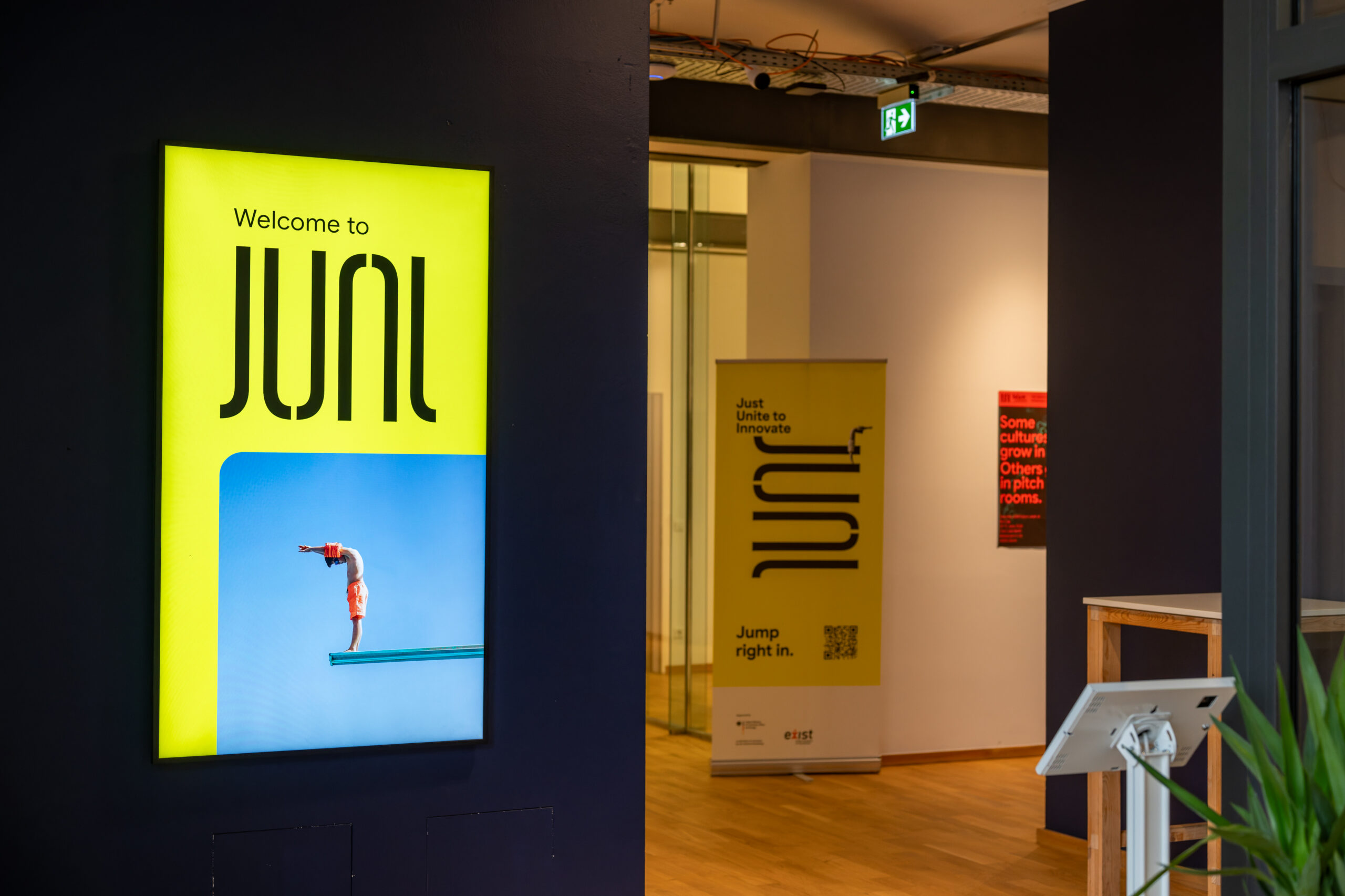 Vertical digital signage welcoming visitors to the JUNI office space.