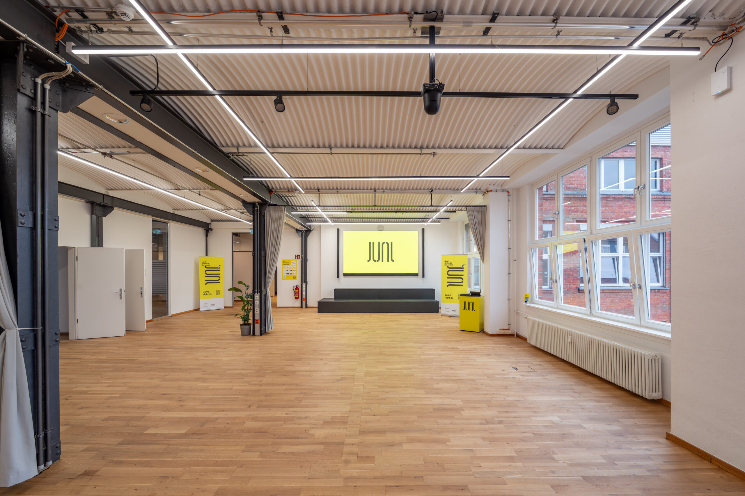 Modern industrial event space with wood floors and track lighting.