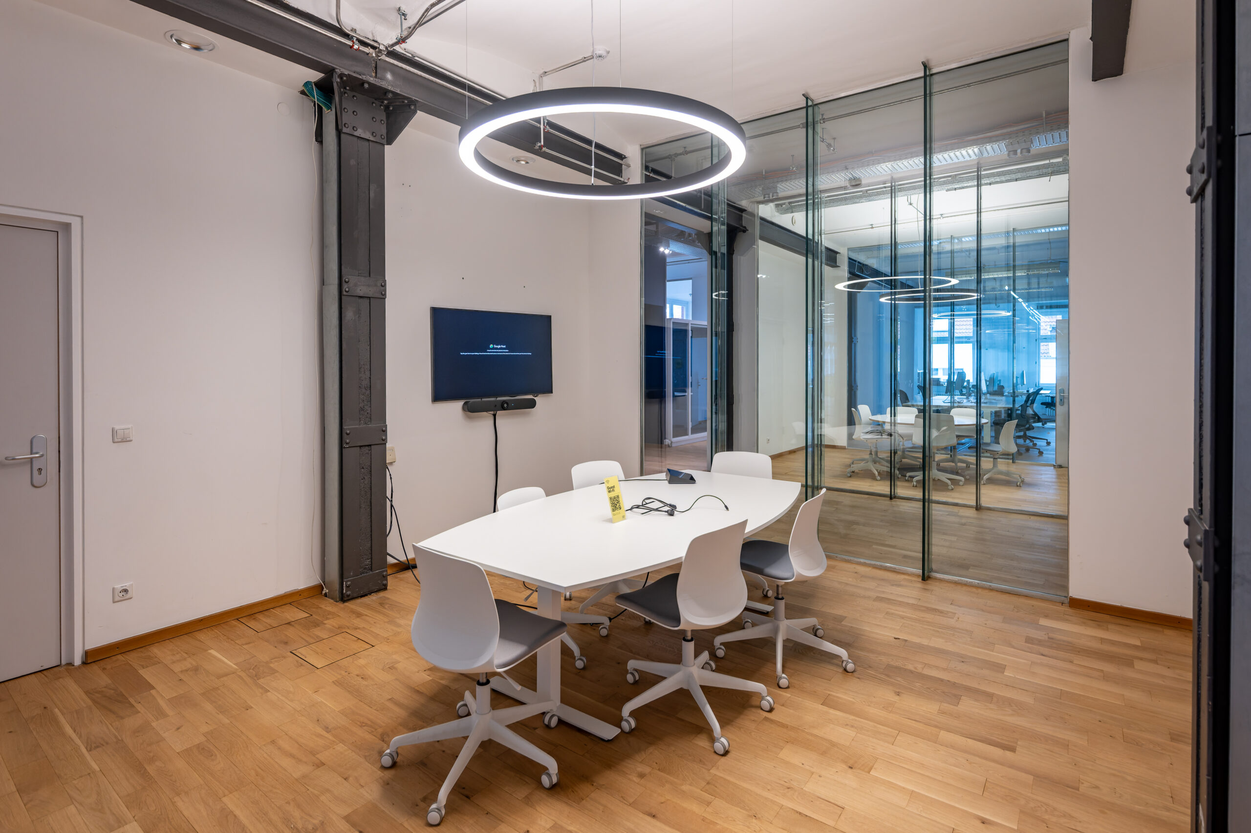 Modern conference room with white furniture and circular LED light.
