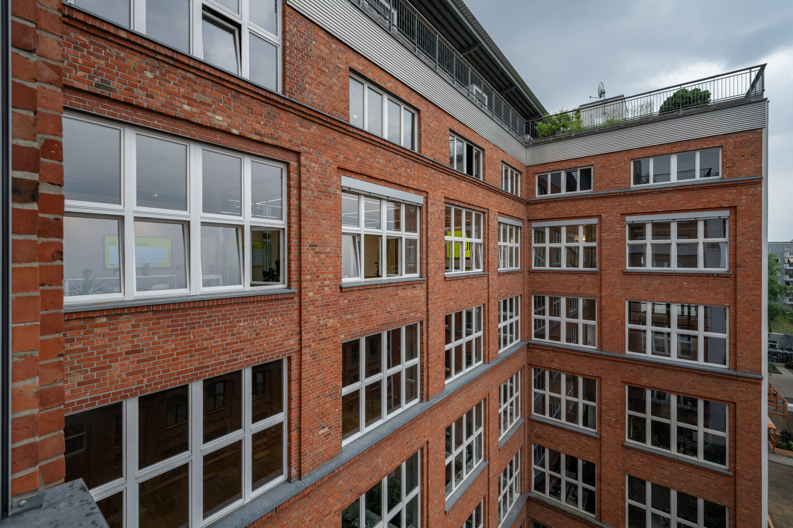 A large red brick building with many white-framed windows.